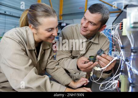 apprendista dell'assemblaggio elettronico che guarda i fili Foto Stock