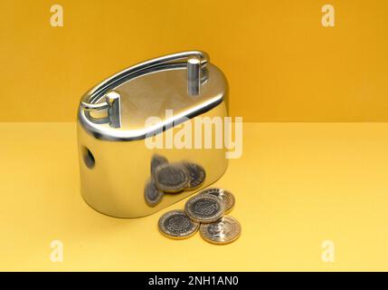 Monete metalliche e lire turche su sfondo giallo. Foto Stock