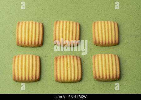 Biscotti all'uovo e al latte isolati su fondo verde Foto Stock