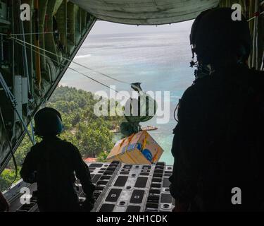 Japan Air Self-Defense Force Chief Master Sgt. Tatsuhiro Kurimoto e staff Sgt. Ikkei Ono, C-130H Hercules loadmasters spingere un pacchetto fuori sull'isola di Murilo durante l'operazione Christmas Drop, 6 dicembre 2022. L'operazione Christmas Drop è un'operazione annuale negli Stati Uniti La tradizione dell'aeronautica militare di imballaggio e consegna delle forniture donate quali cibo, attrezzatura da pesca, libri scolastici e abbigliamento a più di 20 mila isolani in 56 isole remote in tutti gli stati federati di Micronesia e la Repubblica di Palau. Foto Stock