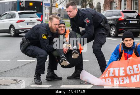 Hannover, Germania. 20th Feb, 2023. Gli ufficiali di polizia trasportano gli attivisti del gruppo 'ultima generazione', che in precedenza erano stati attaccati all'asfalto, fuori strada al Deisterkreisel. Credit: Julian Stratenschulte/dpa/Alamy Live News Foto Stock