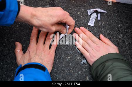 Hannover, Germania. 20th Feb, 2023. Gli attivisti del gruppo 'ultima generazione' attaccano le mani sulla strada al Deisterkreisel, bloccando il traffico per quasi un'ora. Credit: Julian Stratenschulte/dpa/Alamy Live News Foto Stock