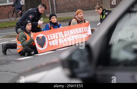 Hannover, Germania. 20th Feb, 2023. Gli agenti di polizia cercano di liberare le mani bloccate degli attivisti del gruppo 'ultima generazione' dalla strada al Deisterkreisel con olio da cucina. Credit: Julian Stratenschulte/dpa/Alamy Live News Foto Stock