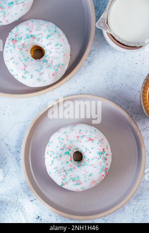 Ciambella in smalto bianco con gli spruzzi colorati Foto Stock