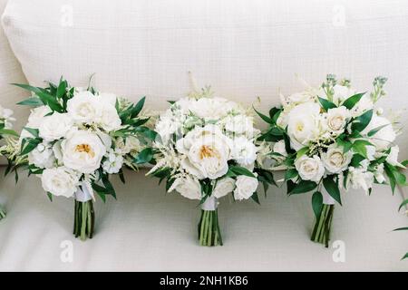 tre bouquet di nozze con tutti i fiori bianchi e verde su biancheria Foto Stock