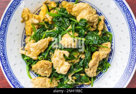 Tradizionale pasto cinese fritto vegetariano con uova e spinaci Foto Stock