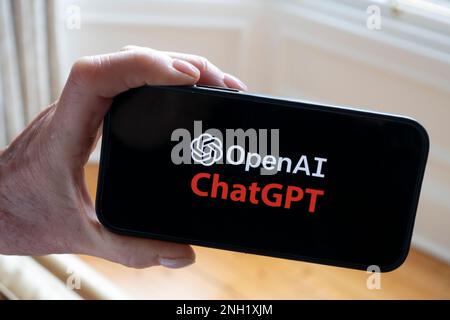 La persona tiene il telefono cellulare che mostra il logo Microsoft ChatGPT OpenAI chatbot sullo schermo Foto Stock