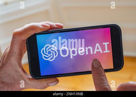 La persona tiene il telefono cellulare che mostra il logo Microsoft ChatGPT OpenAI chatbot sullo schermo Foto Stock