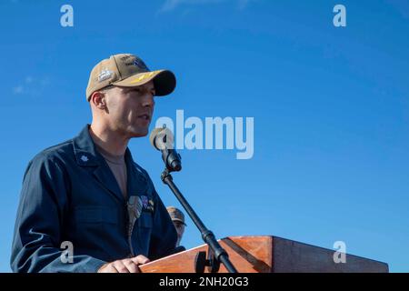 221207-N-SN516-4006 OCEANO PACIFICO (07 DICEMBRE 2022) STATI UNITI Navy CMdR. Mathhew Furtado, ufficiale esecutivo a bordo del cacciatorpediniere missilistico guidato di classe Arleigh Burke USS Decatur (DDG 73), di Raynham, Mass., si rivolge all'equipaggio durante un appello a tutte le mani per commemorare il 81st° anniversario di Pearl Harbor. Decatur, parte del Nimitz Carrier Strike Group, è attualmente in corso di svolgimento di operazioni di routine. Foto Stock