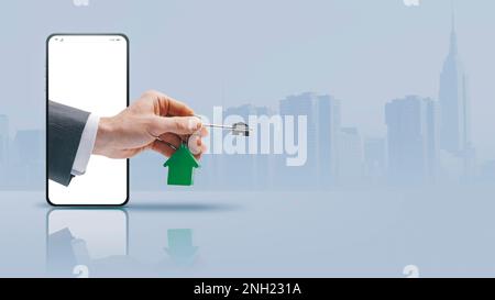 Agente immobiliare mano in uno schermo di smartphone tenendo i vostri nuovi tasti casa, concetto di app immobiliare, spazio di copia Foto Stock