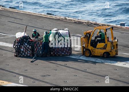 221208-N-BR419-1071 PHILIPPPINE SEA (8 dicembre 2022) i marinai preparano il carico per il trasporto sul ponte di volo degli Stati Uniti L’unica portaerei della Marina schierata a termine, la USS Ronald Reagan (CVN 76), durante un rifornimento verticale con la nave militare Sealift Command, USNS Charles Drew (T-AKE 10), nel Mar delle Filippine, il 8 dicembre. Commander, Logistics Group Western Pacific/Task Force 73 è il gruppo statunitense La prima organizzazione di logistica mobile marittima della Marina che supporta la settima area operativa della flotta. Situato nel sud-est asiatico COMLOG WESTPAC in congiunzione con il Mare militare Foto Stock