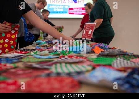 Un bambino militare sceglie un pezzo di tessuto durante un evento fai da te presso la Dyess Air Force base, Texas, 8 dicembre 2022. Dopo aver scelto il loro tessuto, i bambini militari hanno attraversato più stazioni, mentre gli è stato insegnato come le loro calze natalizie sono state messe insieme prima di essere completate. Dopo aver ricevuto le calze, i bambini sono stati anche in grado di scegliere i tessuti per creare calze per un bambino adottivo nella comunità locale di Abilene. tessuti, vacanze, bambini militari, Foto Stock