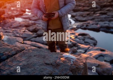 Uomo bearded che utilizza un drone con telecomando per realizzare foto e video, divertendosi con le nuove tendenze tecnologiche Foto Stock