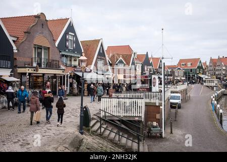 I turisti camminano lungo la passeggiata sul lungomare passando per i negozi e i caffè nella città di Volendam, nei Paesi Bassi. Foto Stock