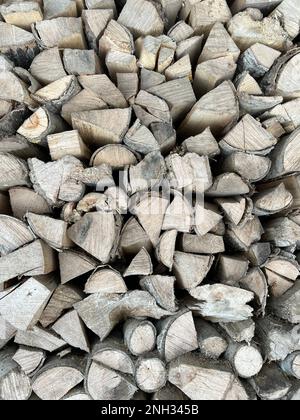 Sfondo in legno naturale. Legna da ardere accatastata e preparata per l'inverno pila di tronchi di legno. Tronchi di legno naturale segato come sfondo Foto Stock