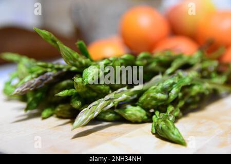 Mazzo di asparagi selvatici su un tavolo di legno Foto Stock