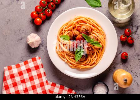 Spaghetti con polpette e salsa di pomodoro su sfondo di pietra, vista dall'alto Foto Stock