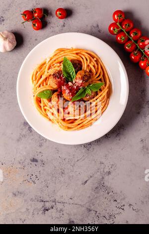 Spaghetti con polpette e salsa di pomodoro su sfondo di pietra, vista dall'alto Foto Stock