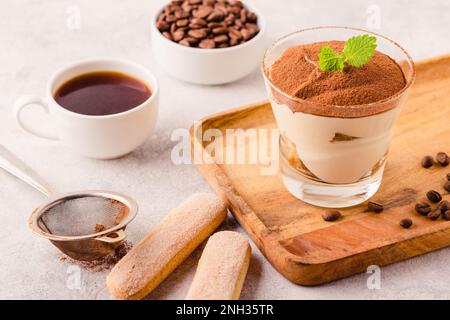 Tiramisù tradizionale dessert italiano in un bicchiere, focus selettivo Foto Stock
