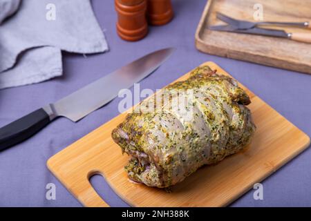 Coscia di tacchino sull'osso, cotta con senape, prezzemolo, spezie e peperoncino su tavola di legno. Primo piano. Foto Stock