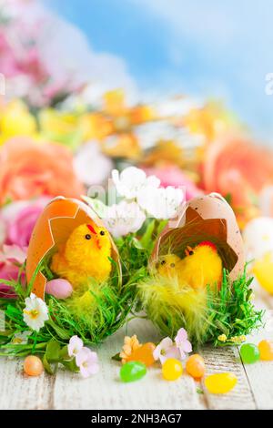 Decorazione pasquale con pulcini, uova e fiori Foto Stock