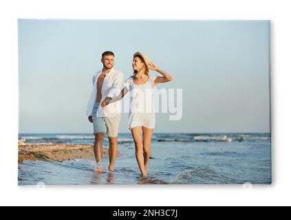 Foto stampata su tela, sfondo bianco. Felice giovane coppia sulla spiaggia Foto Stock