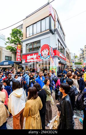 Persone e turisti che camminano davanti a una filiale della catena americana di ristoranti fast food, Wendys First Kitchen, in Takeshita Street, Harajuku, Tokyo. Foto Stock