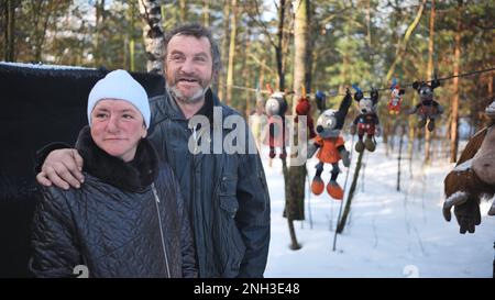 Un uomo e una donna senza casa che dà un'intervista in inverno nei boschi. Foto Stock