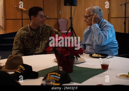 STATI UNITI Air Force 2nd Lt. Joseph Harclerode, 325th ufficiale per gli affari pubblici di Fighter Wing, parla con un veterano senior presso la base dell'aeronautica militare di Tyndall, Florida, 9 dicembre 2022. I veterani senior locali che hanno partecipato al Golden Age Holiday Party annuale 32nd di Tyndall hanno avuto l'opportunità di incontrare i dirigenti di base e gli Airmen da tutta l'installazione. Foto Stock