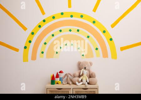 Carino interno della stanza del bambino con il sole bello dipinto sulla parete Foto Stock