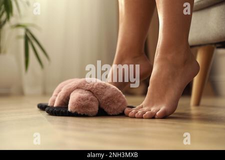 Donna con soffici pantofole a casa, primo piano Foto Stock