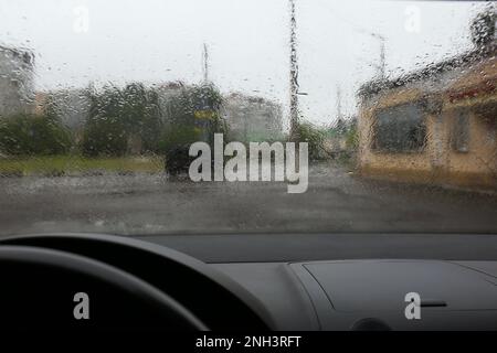 Gocce di pioggia sul parabrezza, vista dall'interno Foto Stock