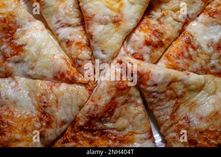 Primo piano di una pizza ​​homemade al forno e affettata con formaggio e salsa di pomodoro Foto Stock