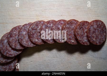 Affettare ​​garlic fette di salsiccia su un tagliere di legno Foto Stock