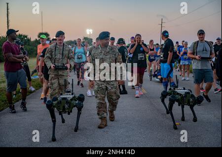 I membri dello Squadrone delle forze di sicurezza del 45th camminano con due Ghost Robotics Vision 60 Quadruped Unmanned Ground Vehicles (Q-UGV) fino alla linea di partenza della forza spaziale T-Minus 10-Miler presso Cape Canaveral Space Force Station, Fla., 10 dicembre 2022. La gara T-Minus 10-Miler, organizzata da Space Launch Delta 45, si terrà il prossimo anno il 9 dicembre 2023. Foto Stock