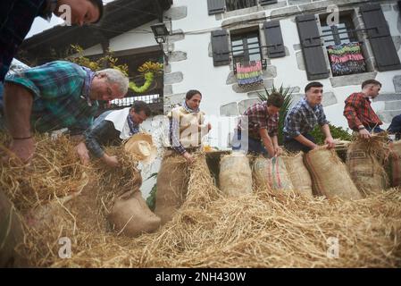 Lesaka, Spagna. 18th Feb, 2023. Diversi partecipanti al carnevale riempiono i loro costumi di paglia, ed è per questo che gli uomini con il vecchio sacco ripieno di paglia sono chiamati 'zaku-zaharrak', al carnevale di Lesaka. Gli 'zaku-zaharrak' sono caratteri tipici del carnevale di Lesaka, ripieni di sacchi pieni di paglia con le loro facce coperte da sciarpe, che portano i neri gonfiati per colpire le persone che camminano per le strade della città al tramonto. (Foto di Elsa A Bravo/SOPA Images/Sipa USA) Credit: Sipa USA/Alamy Live News Foto Stock