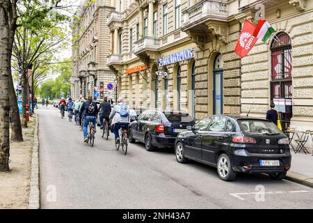 Gruppo di turisti ciclisti con zaini viaggia attraverso la città vecchia. Vista posteriore. Paesaggio urbano. Primo piano. Spazio di copia. Budapest, Ungheria-maggio 2019 Foto Stock