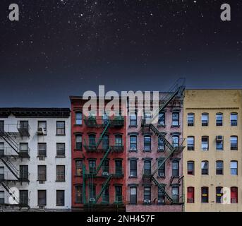 Vecchi edifici di appartamenti colorati di New York City con cielo notturno pieno di stelle sopra Foto Stock