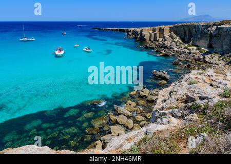 Barche ormeggiate nelle acque turchesi di Cala Rossa, Favignana Foto Stock