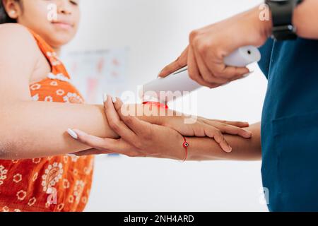 Terapia laser usata sul braccio per trattare il dolore, primo piano del fisioterapista usando la terapia laser sul braccio del paziente. Fisioterapia laser moderna sulla donna Foto Stock