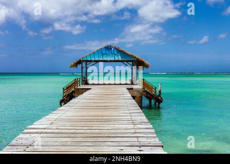 Isola di Tobago, Trinidad e Tobago. Un iconico molo sul tetto di paglia presso il Pigeon Point Heritage Park situato a sud-ovest della costa dell'isola di Tob Foto Stock