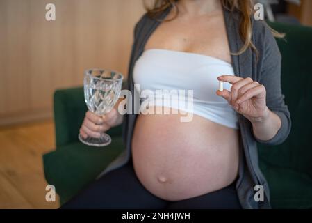 Donna in gravidanza che assume capsula composta Foto Stock