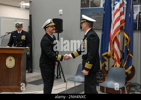 221213-N-ZS023-1044 SAN DIEGO (13 dicembre 2022) CMdR. Christopher Polnaszek, centro, comandante della nave litoranea indipendente-variante unità di Pre-Commissioning Augusta (LCS 34), si congratula con il Capt. Marc Crawford, commodore della nave da combattimento litoranea Squadron ONE, durante una cerimonia di assunzione del comando tenuta alla nave da combattimento litoranea Squadron ONE. Le navi da combattimento Littoral sono combattenti di superficie veloci, con un equipaggio ottimale e personalizzati in base alle missioni, che operano in ambienti vicino alla costa e all'aperto, vincendo contro le minacce costiere del 21st° secolo. LCS si integrano con le congiunte, combinate, presidiate e unman Foto Stock