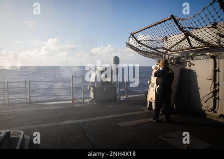 221213-N-YV347-1119 OCEANO PACIFICO (13 dicembre 2022) l'incrociatore missilistico guidato di classe Ticonderoga USS Bunker Hill (CG 52) attiva la mitragliatrice MK da 38 25 mm durante un esercizio di fuoco vivo. Bunker Hill, parte del Nimitz Carrier Strike Group, è attualmente in corso di svolgimento di operazioni di routine. Foto Stock