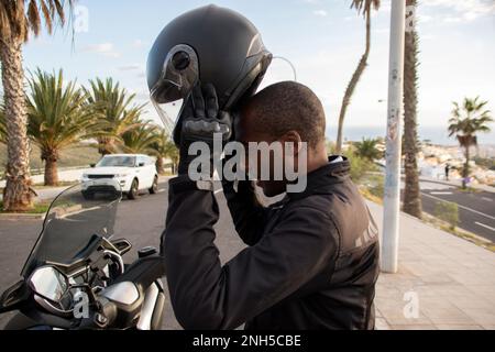 Sorridente ciclista afro-americana indossando il casco integrale. Concetto di sicurezza stradale Foto Stock