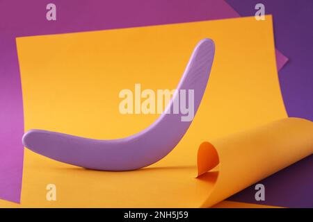 Composizione creativa con boomerang lilla in legno su sfondo colorato Foto Stock