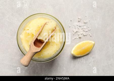 Scrub corpo con paletta, sale marino e limone su tavolo grigio chiaro, piatto Foto Stock