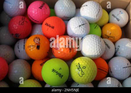 Palline da golf colorate in scatola di cartone Foto Stock