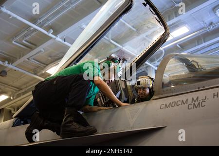 220718-N-LM220-1045 OCEANO PACIFICO (18 luglio 2022) Aviation Structural Mechanic (Safety Equipment) Airman Zhibin He, a sinistra, da Canton, Cina, E Aviation Structural Mechanic (Safety Equipment) 2nd Class Michaela Davies, di Oakland, California, pulisce un F/A-18E Super Hornet, assegnato ai “Vigilantes” di Strike Fighter Squadron (VFA) 151, nella hangar Bay a bordo della portaerei di classe Nimitz USS Abraham Lincoln (CVN 72). Abraham Lincoln Carrier Strike Group sta conducendo operazioni di routine nella flotta degli Stati Uniti 3rd. Foto Stock