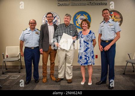 Aaron Demo, ispettore di viaggio capo con ispezione di viaggio della Guardia Costiera, supporto di formazione e Centro Nazionale di personale di competenza a Washington, D.C., E il capitano Jason Smith, comandante del settore della Guardia Costiera Houston-Galveston, posa con l'esperto di gas naturale liquefatto ed Carr e i suoi familiari durante una cerimonia al Sector Houston-Galveston di Houston, Texas, il 19 luglio 2022. Demo ha conferito a Carr un premio meritorio per il servizio pubblico per aver sostenuto il Centro Nazionale di competenza LGC della Guardia Costiera dal 2014 al 2019. Foto Stock